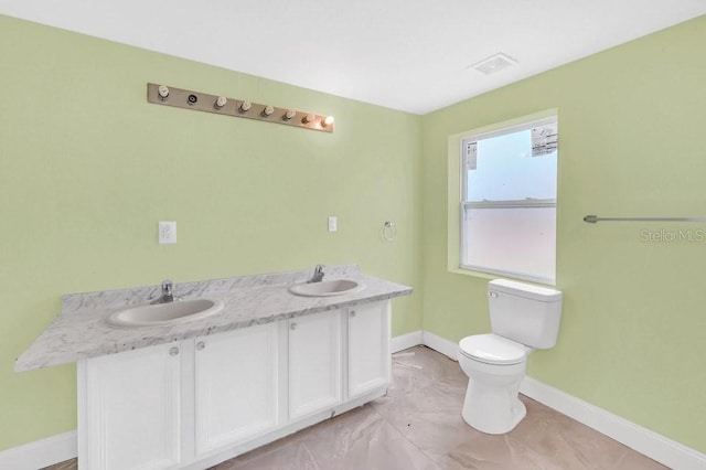 5351 E Johnson Ave, Haines City, FL 33844 - bathroom with toilet, visible vents, a sink, and baseboards