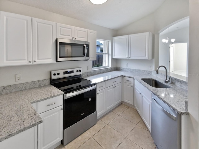 kitchen with white cabinetry, stainless steel appliances, and vaulted ceiling