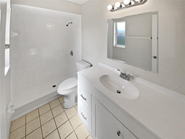 bathroom with vanity, toilet, walk in shower, and tile patterned flooring