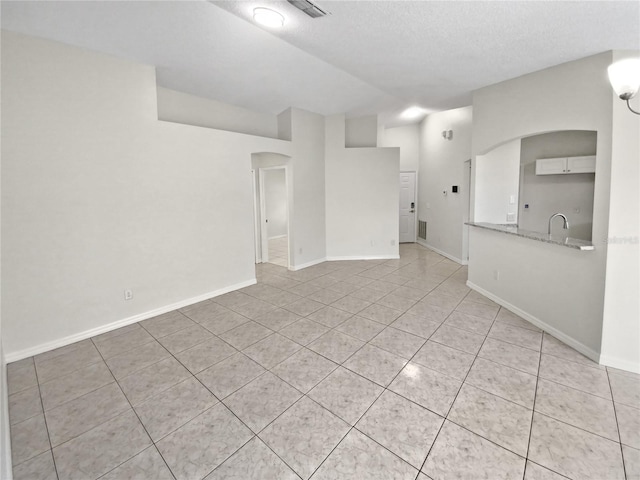 unfurnished living room featuring light tile patterned floors and a textured ceiling