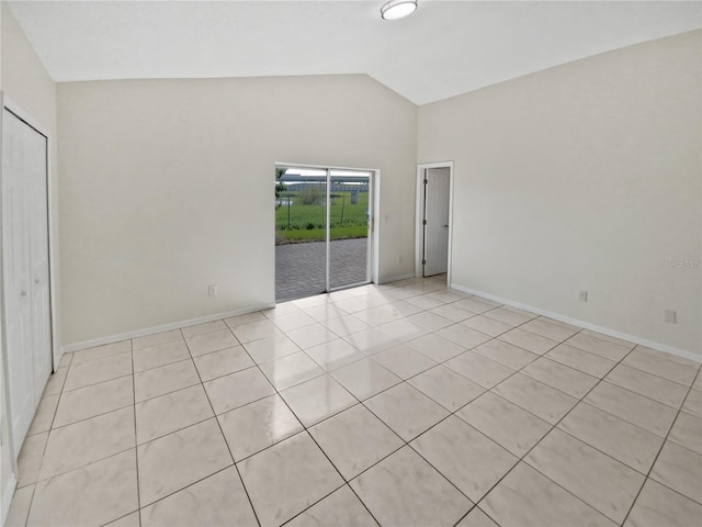 tiled empty room with vaulted ceiling