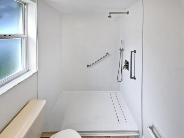 bathroom featuring toilet and tiled shower