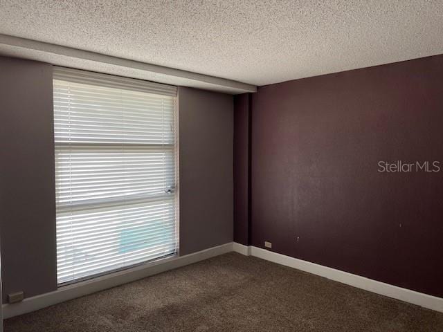 carpeted spare room featuring a textured ceiling