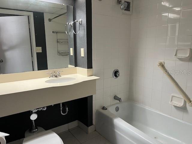 full bathroom with tiled shower / bath combo, vanity, toilet, and tile patterned floors