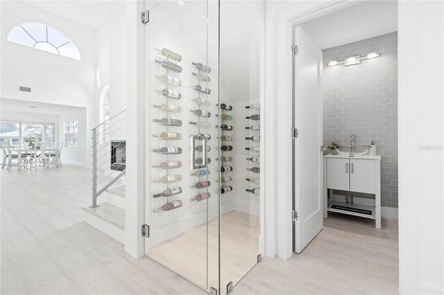 wine room featuring light hardwood / wood-style flooring and tile walls