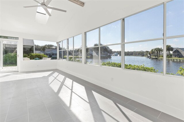 unfurnished sunroom featuring ceiling fan, vaulted ceiling, and a water view