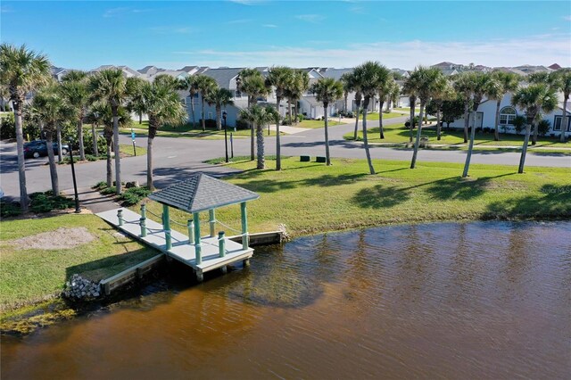 dock area with a lawn and a water view