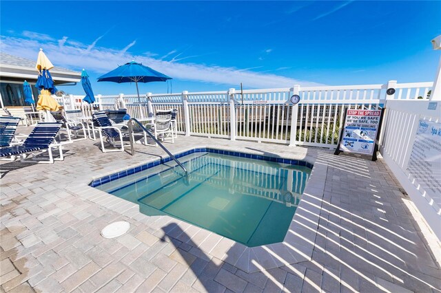 view of pool featuring a hot tub and a patio area