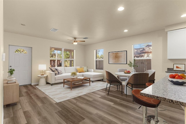 living room with light hardwood / wood-style flooring and ceiling fan