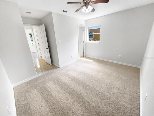 spare room featuring ceiling fan and light carpet