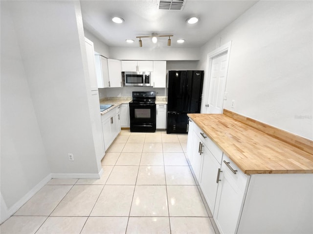 kitchen with butcher block countertops, black appliances, and white cabinetry