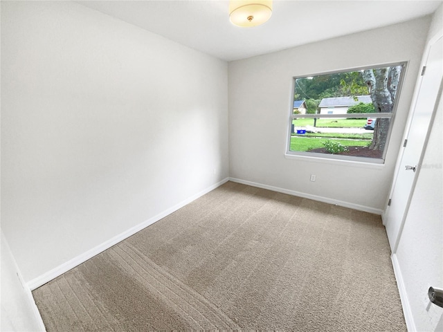 spare room featuring light colored carpet