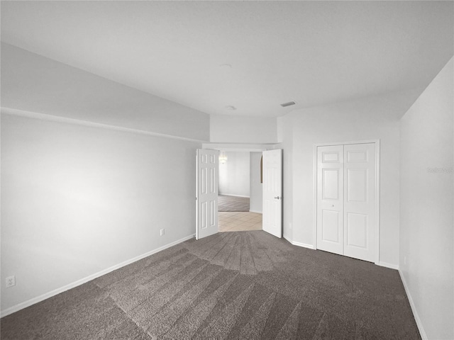 unfurnished bedroom with light carpet and a closet