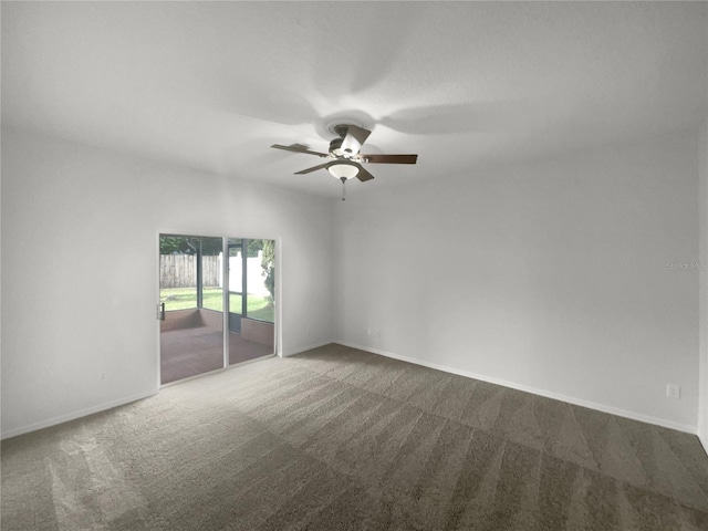 spare room with ceiling fan and dark colored carpet