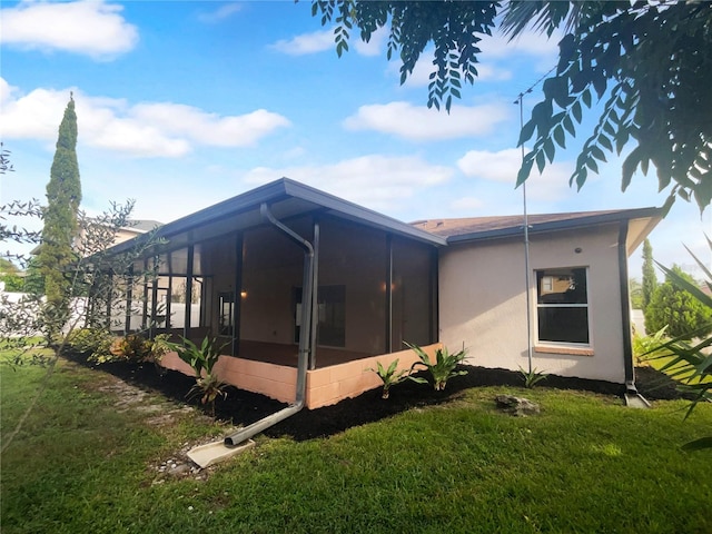 view of side of home with a lawn and a sunroom