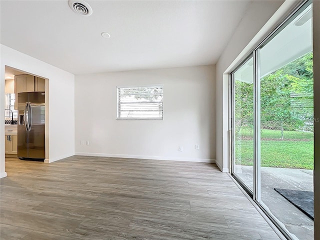 unfurnished living room with light hardwood / wood-style flooring and sink