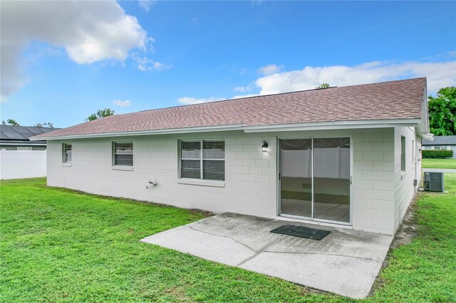 rear view of property with a patio area, a yard, and cooling unit