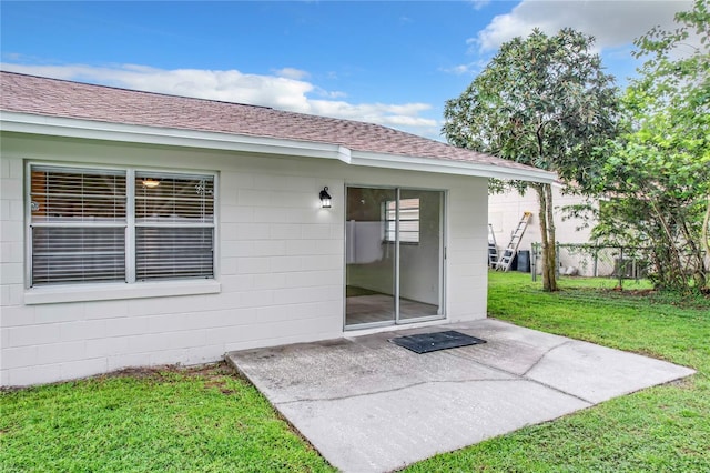 back of house with a lawn and a patio