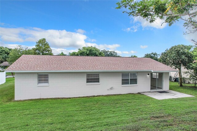 rear view of house featuring a patio area and a lawn