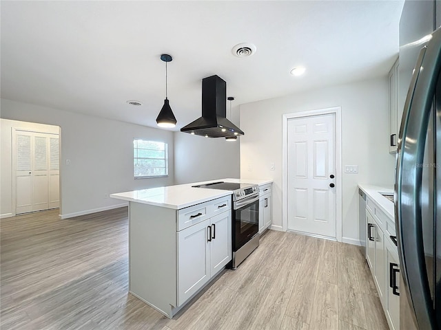 kitchen with pendant lighting, light hardwood / wood-style flooring, exhaust hood, kitchen peninsula, and appliances with stainless steel finishes