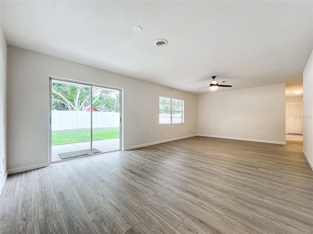 spare room with light wood-type flooring and ceiling fan