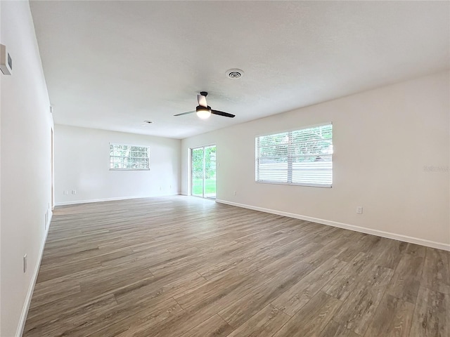 empty room with ceiling fan and hardwood / wood-style floors