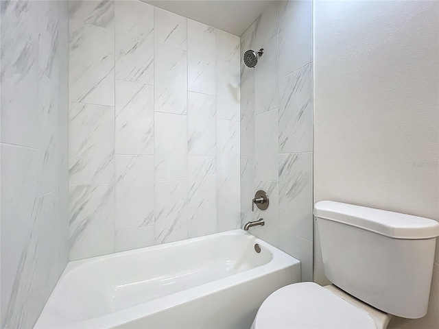 bathroom featuring tiled shower / bath and toilet