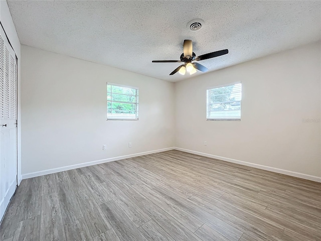 interior space with light hardwood / wood-style flooring, ceiling fan, and multiple windows