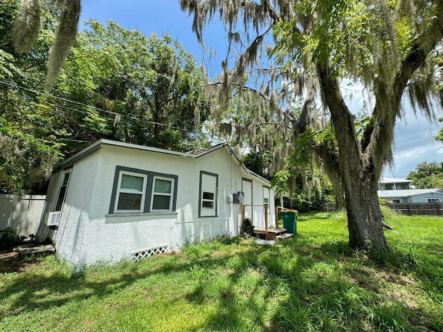 view of property exterior with a lawn and cooling unit