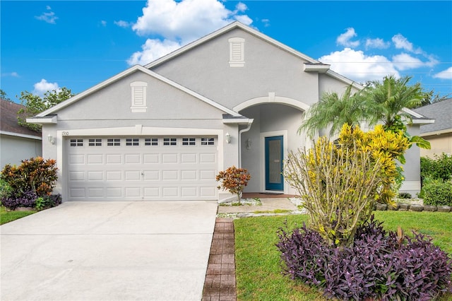 view of front of home with a garage and a front lawn