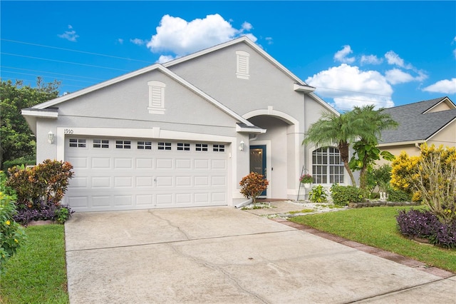 front of property with a garage and a front lawn