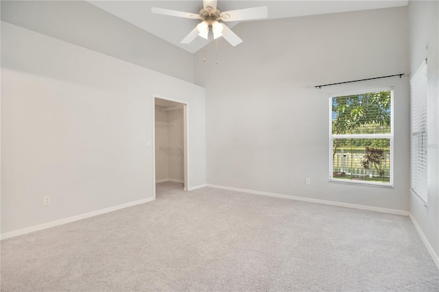 spare room featuring light carpet, ceiling fan, and high vaulted ceiling