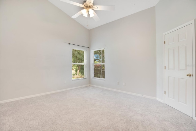 carpeted empty room featuring high vaulted ceiling and ceiling fan