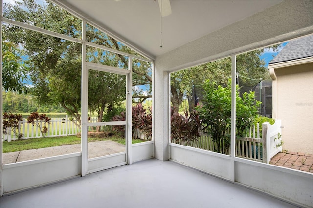 unfurnished sunroom featuring ceiling fan, lofted ceiling, and plenty of natural light