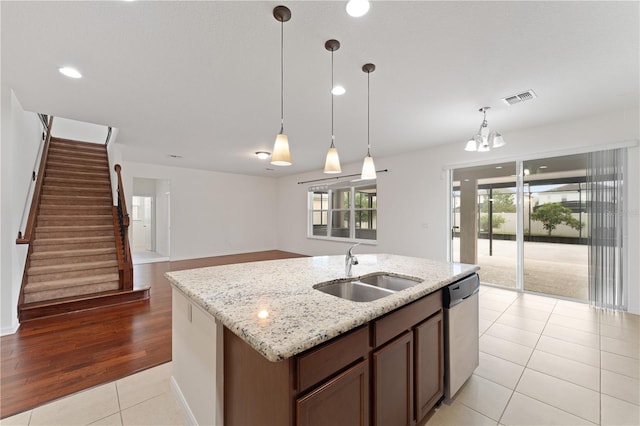 kitchen featuring visible vents, a sink, hanging light fixtures, dishwasher, and open floor plan