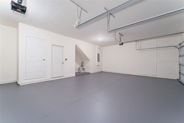 garage featuring electric panel and a garage door opener