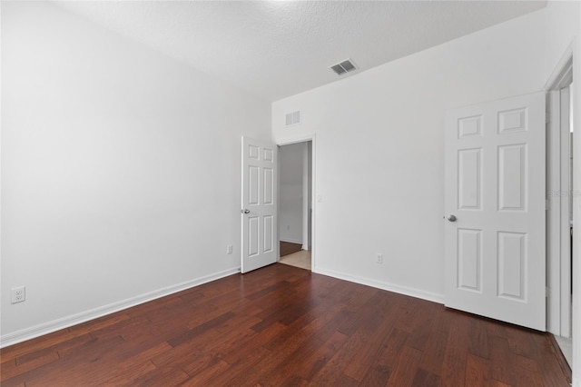 unfurnished bedroom featuring visible vents, baseboards, and wood-type flooring