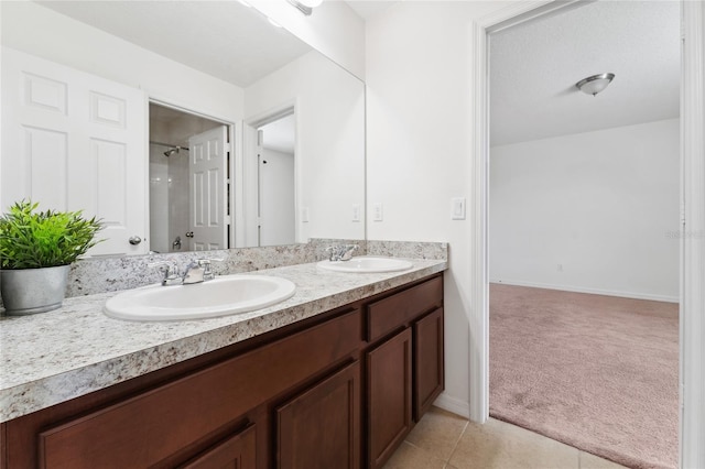 full bathroom with a sink, walk in shower, double vanity, and tile patterned flooring