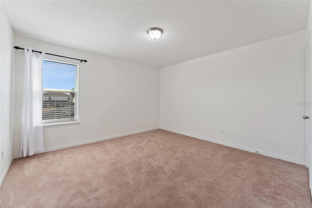 unfurnished room featuring baseboards, a textured ceiling, and carpet flooring