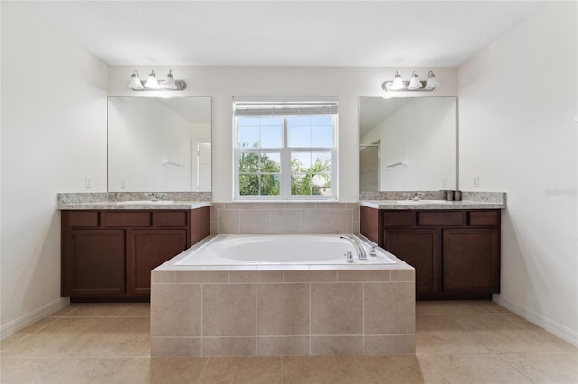 full bath with two vanities, a bath, and a sink