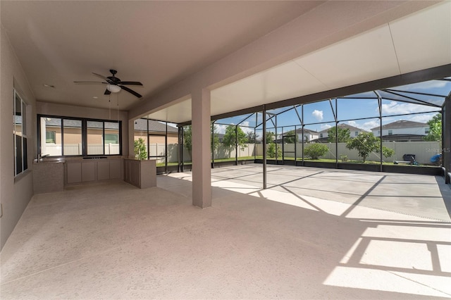 unfurnished sunroom featuring ceiling fan