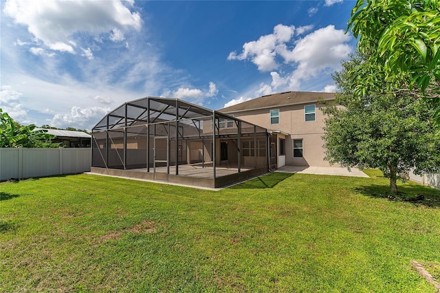 view of yard featuring glass enclosure, a swimming pool, a fenced backyard, and a patio area