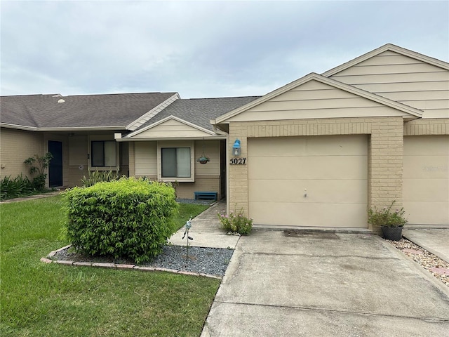 ranch-style home with a garage and a front lawn