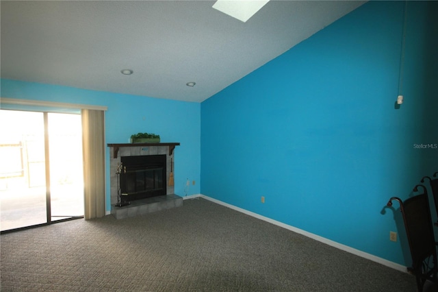 unfurnished living room with carpet floors, a tile fireplace, and lofted ceiling with skylight