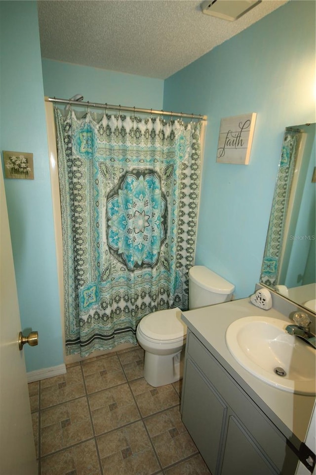 bathroom featuring a shower with curtain, a textured ceiling, vanity, and toilet