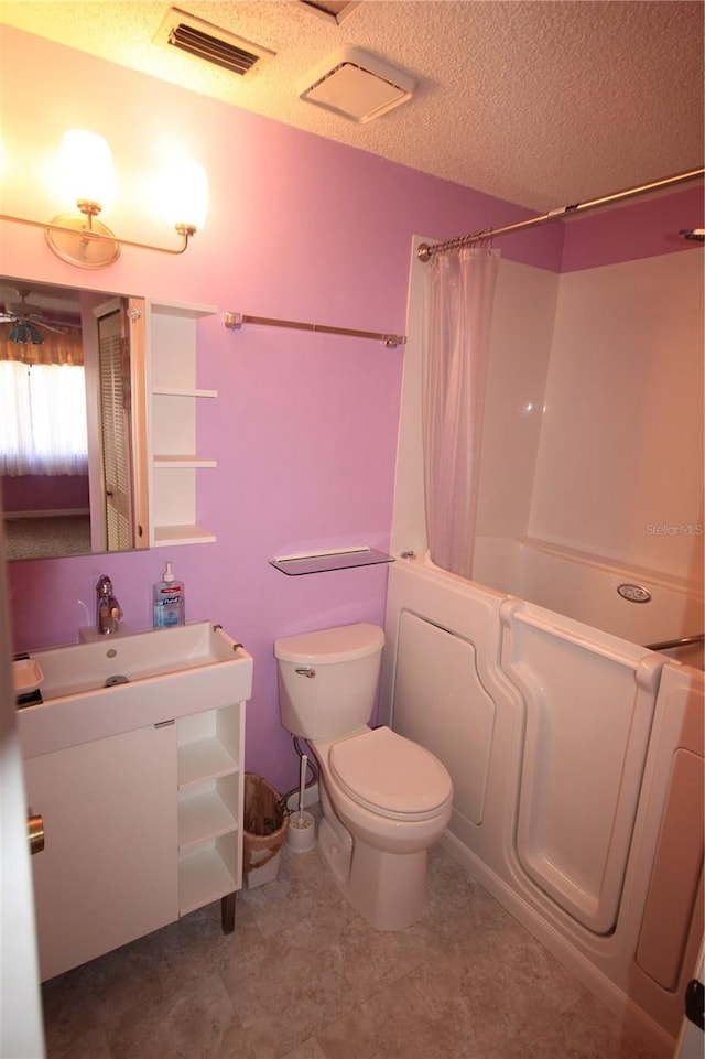 full bathroom featuring a textured ceiling, vanity, toilet, and shower / bath combo with shower curtain