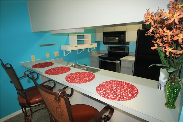 kitchen with a kitchen breakfast bar, sink, and black appliances