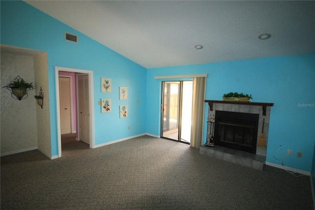 unfurnished living room featuring dark carpet, lofted ceiling, and a tile fireplace