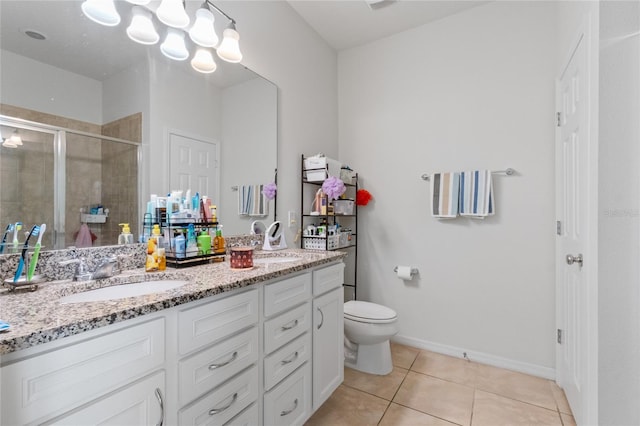 bathroom featuring tile patterned flooring, vanity, toilet, and a shower with shower door