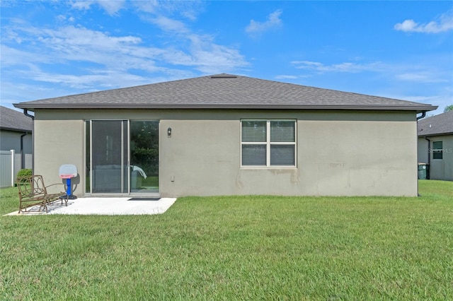 rear view of house with a patio and a yard